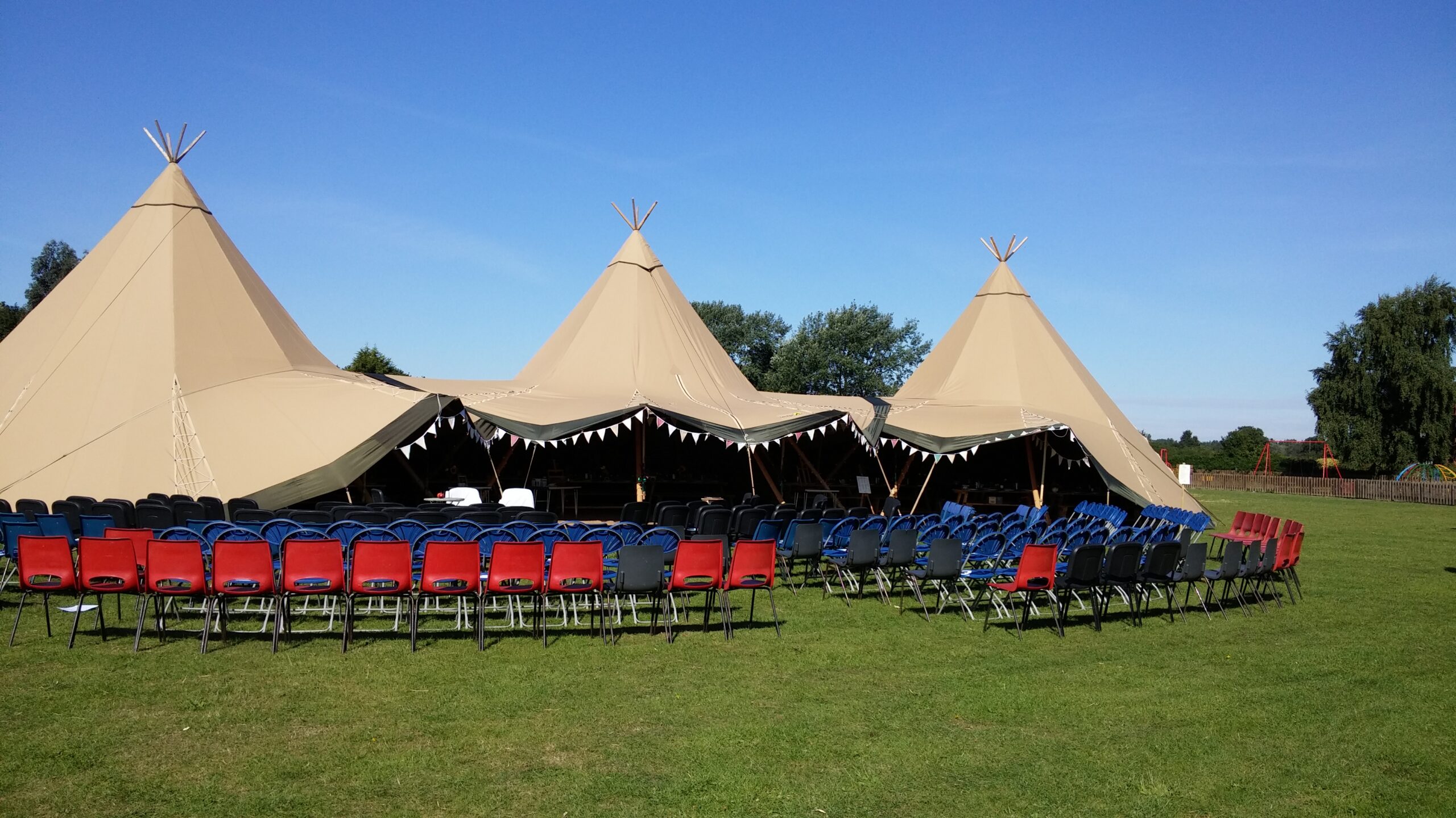 Photo of Teepees and seating set up on the field for a wedding